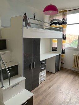 Vyvyšená postel se stolem a skříní