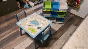 Dětský stolek s židličkami a úložná skříňka s dinosaury.