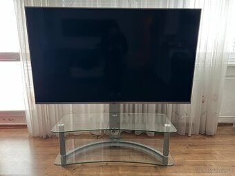televize LG se sklenenym stolkem a držákem