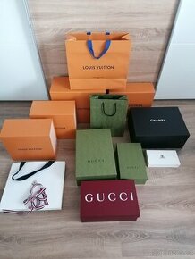 Krabice a tašky Louis Vuitton, Gucci, Chanel