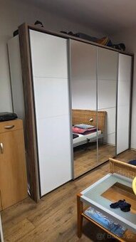 Šatní skříň s posuvnými dveřmi a zrcadlem.