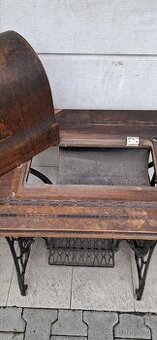 Starožitné podnoží s deskou a krytem šicího stroje.