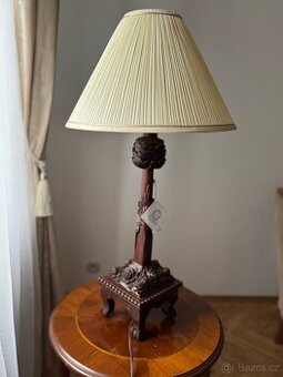 Větší stolní lampa s vyřezávanou nohou ze dřeva a látkovým s