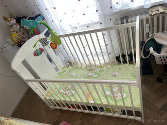 Dětská postýlka se spouštěcí bočnicí.