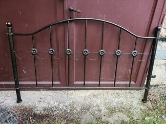 Rozebraná kovová postel s ozdobnými čely