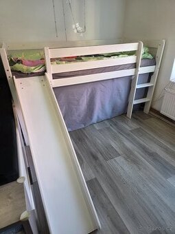 Dětská vyvýšená postel se skluzavkou a bunkrem.