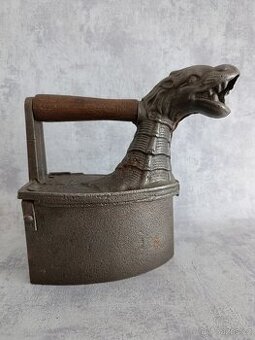 Starožitná litinová kominová žehlička s motivem draka.