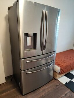 Americká lednice, dětské kolo, myčka nádobí a jídelní stůl.