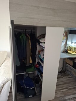 Postel vyvýšená se skříní a stolem - 2
