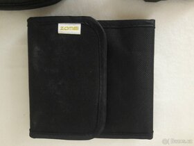 Krytka objektivu, popruh, clona, difuzer, očnice.. - 7